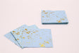 Set of blue napkins with gold splashes on a light pink background